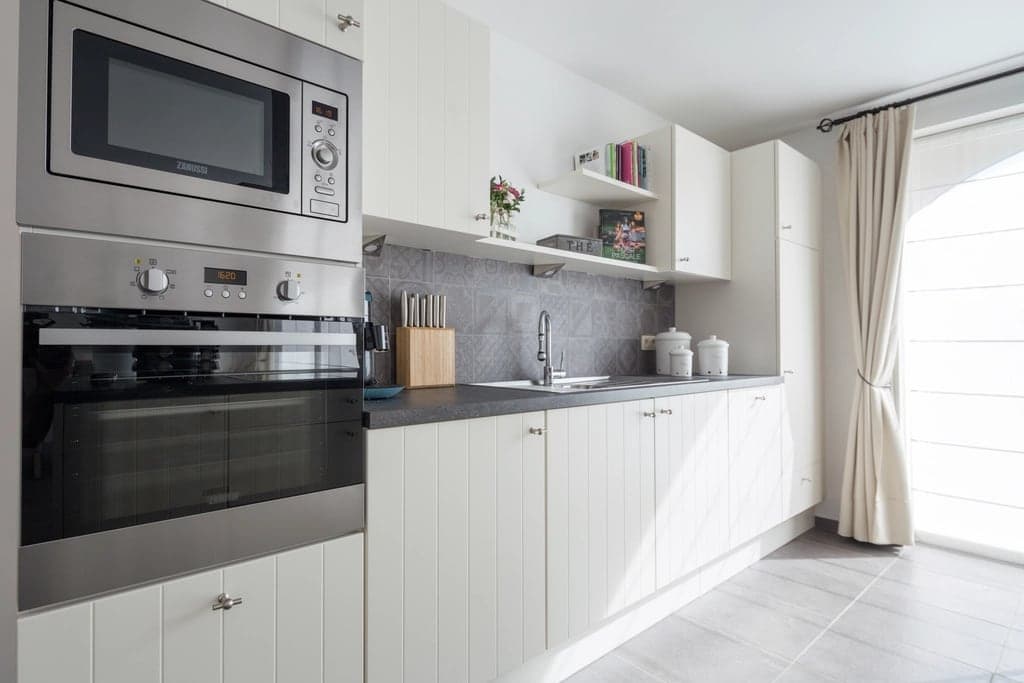 Cozinha residencial clara com micro-ondas e forno embutidos